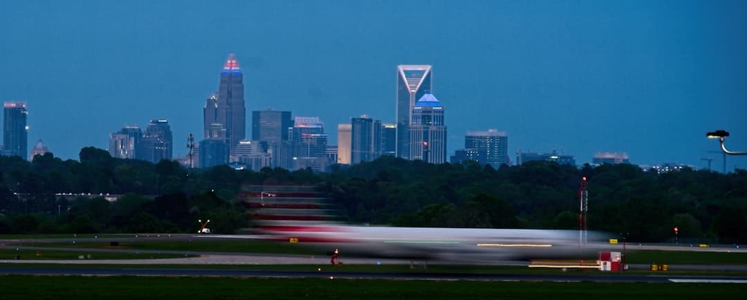 white and red airplane on the city during night time — Photo by Wes Smith on Unsplash