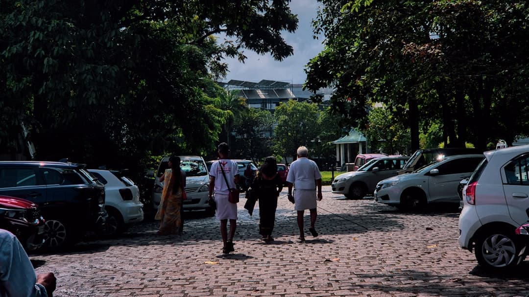 People walking through a parking lot with cars. — Photo by Adhitya Sibikumar on Unsplash