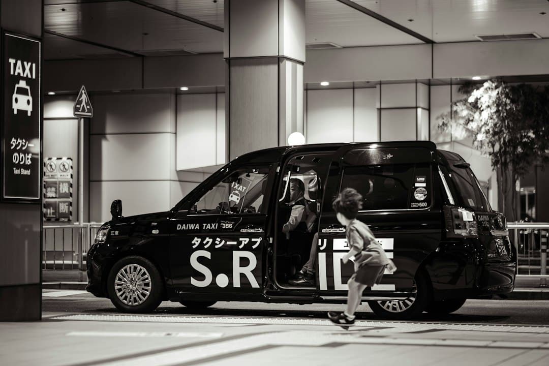 People entering a black taxi on a city street — Photo by Fumiaki Hayashi on Unsplash