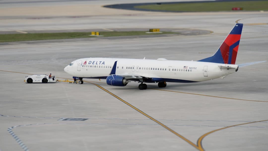 a delta airplane is parked on the tarmac — Photo by Hans Dorries on Unsplash