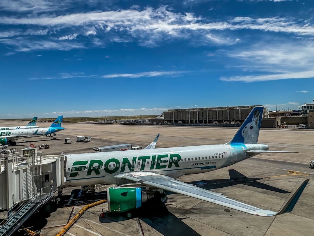 A frontier airplane parked on the tarmac at an airport — Photo by Michael Evans on Unsplash