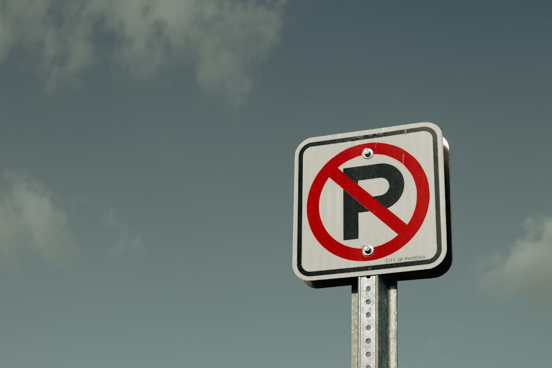 a no parking sign with a sky background — Photo by Allison Astorga on Unsplash