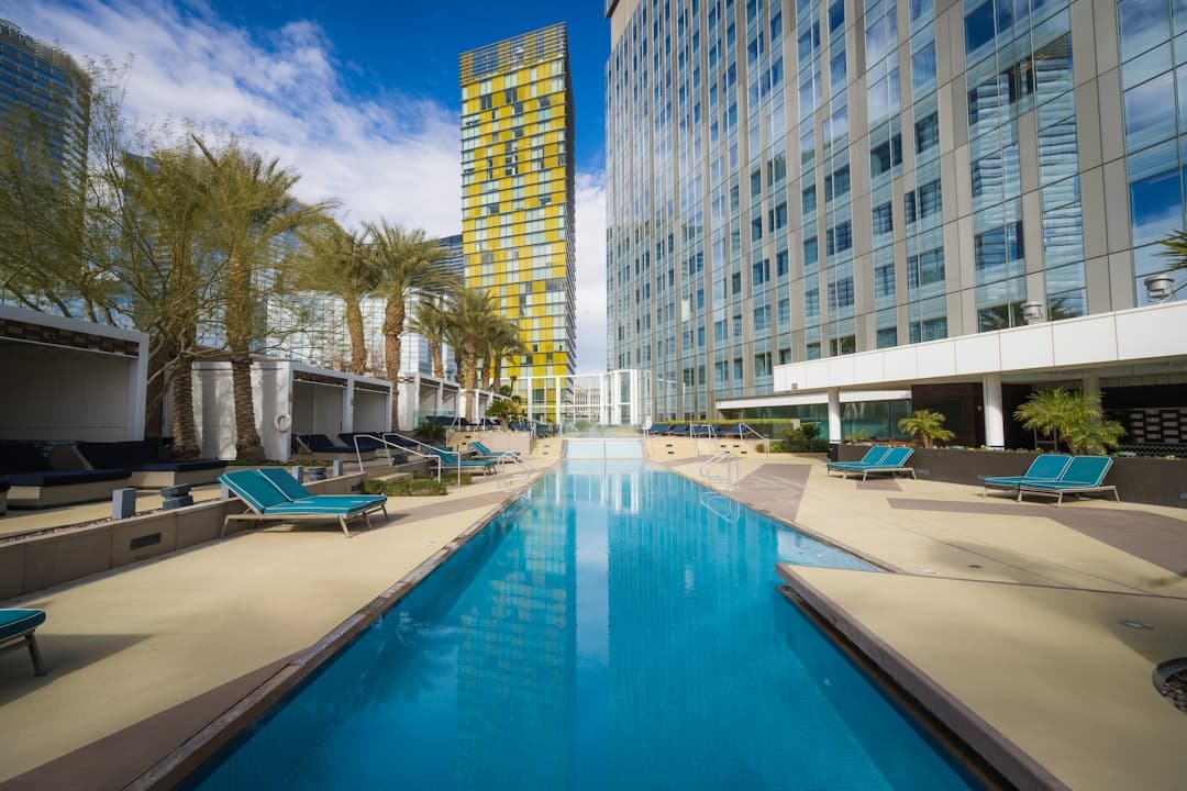 a long swimming pool in front of a tall building — Photo by Frugal Flyer on Unsplash