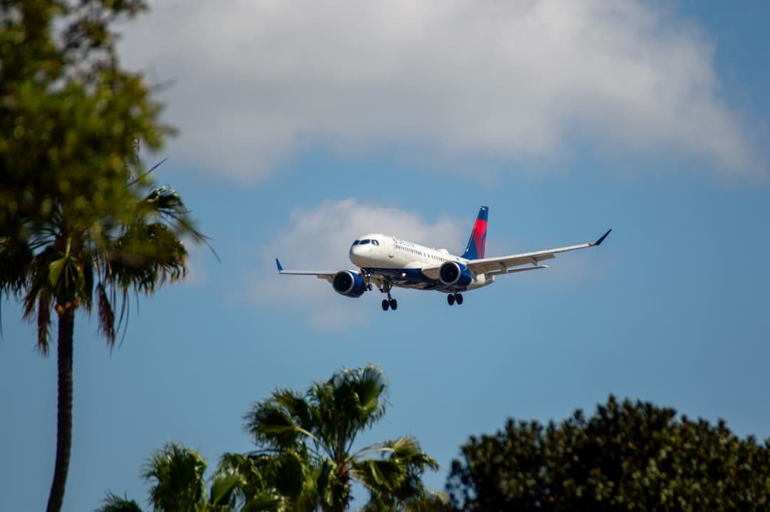 A delta airplane flying through a cloudy sky. — Photo by Alito McBean on Unsplash