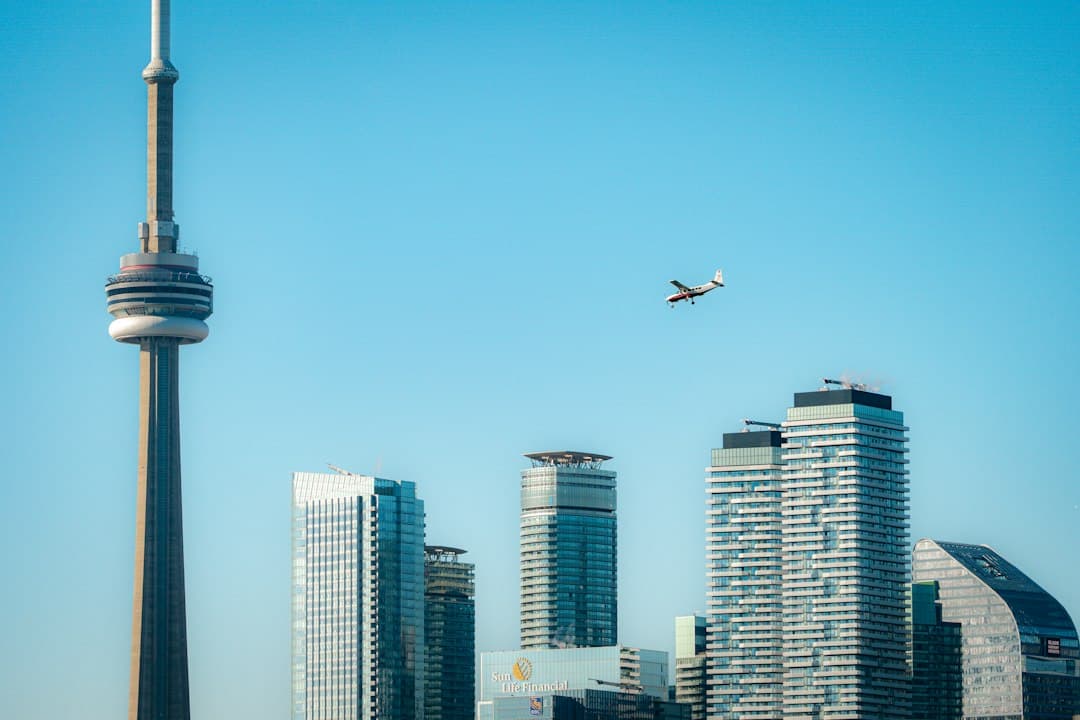 an airplane flying over a city with tall buildings — Photo by Vladyslav Melnyk on Unsplash