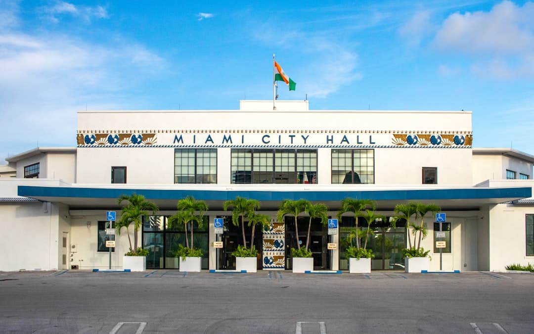 A large white building with a flag on top of it — Photo by Zoshua Colah on Unsplash
