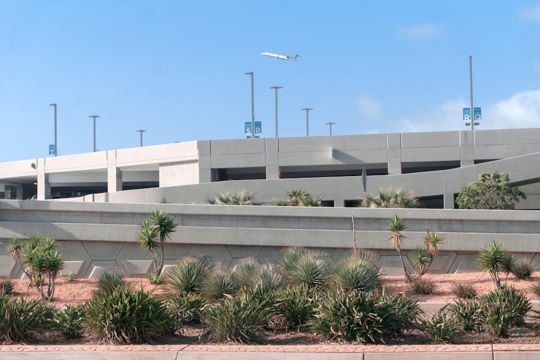 white concrete building near green palm tree under blue sky during daytime — Photo by Anton Mishin on Unsplash