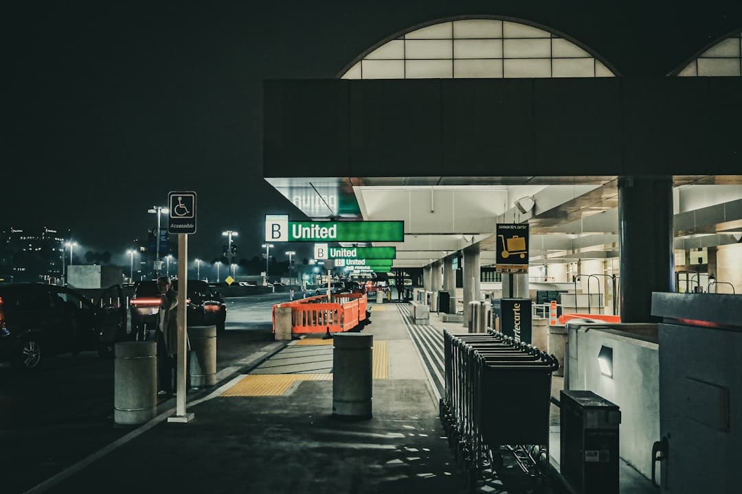Airport terminal entrance at night with united signage. — Photo by Jonathan Phillips on Unsplash