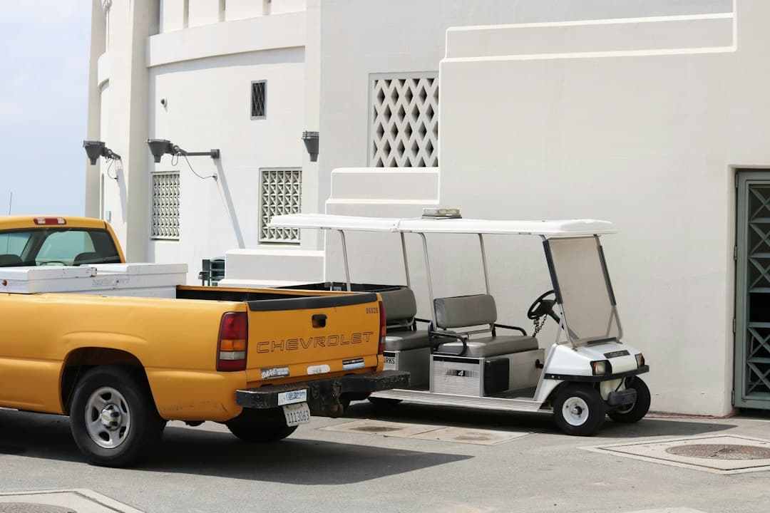 A truck and golf cart parked near a building — Photo by Josh Paek on Unsplash
