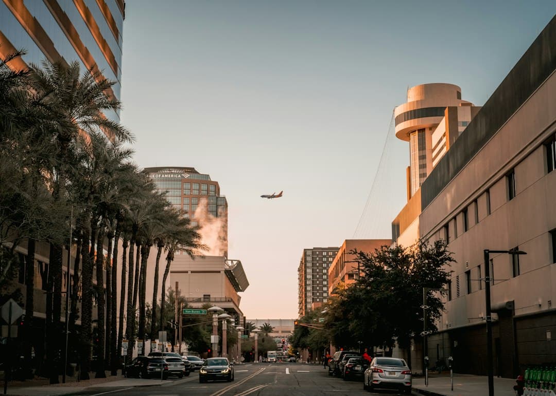 an airplane is flying over a city street — Photo by Robert on Unsplash