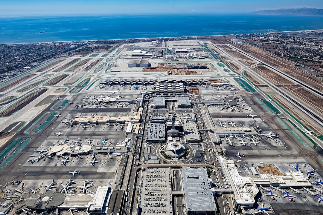Aerial view of a large airport with ocean in background. — Photo by Sean Pierce on Unsplash