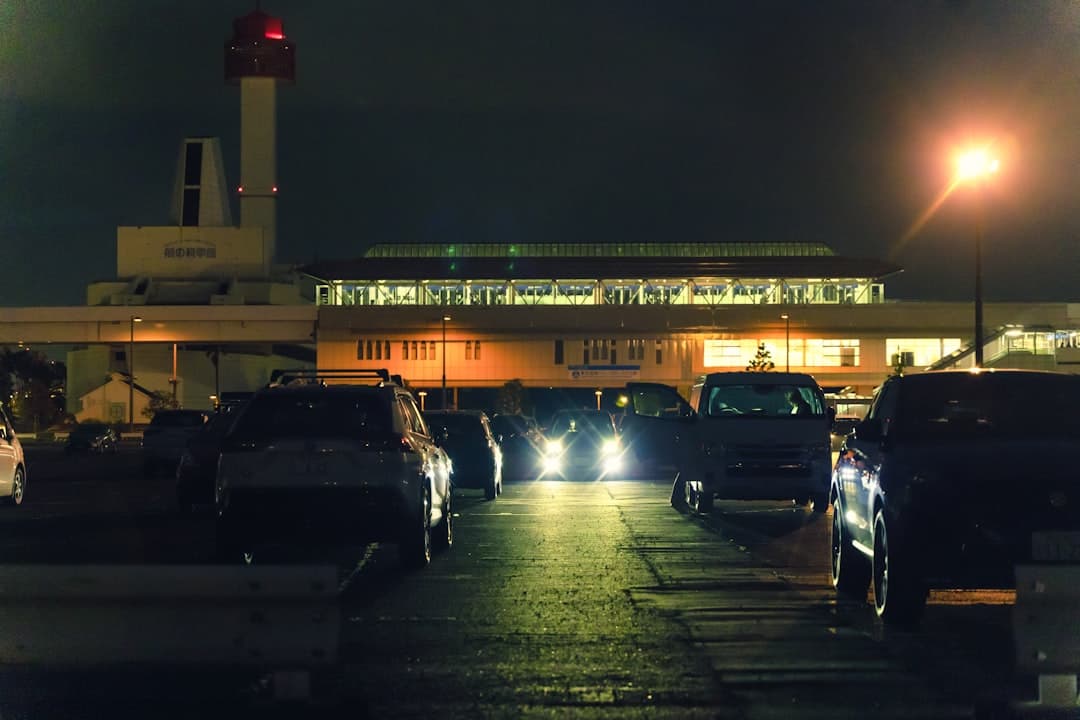 Cars parked outside a modern airport terminal at night. — Photo by ayumi kubo on Unsplash