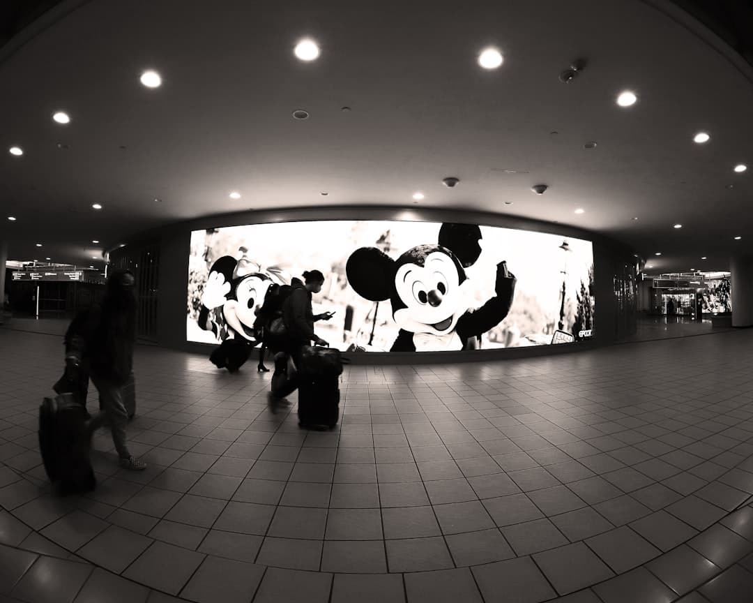 a black and white photo of people with luggage — Photo by Jimmy Blackwell on Unsplash