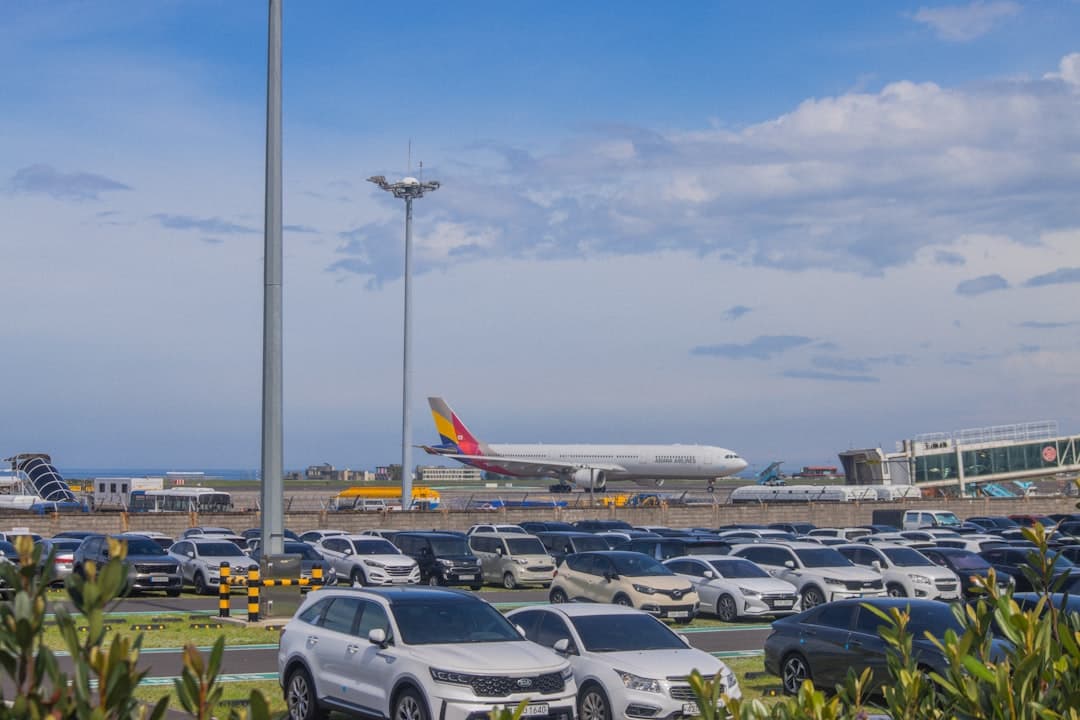 Airplane taxiing on runway with cars in foreground. — Photo by yeojin yun on Unsplash