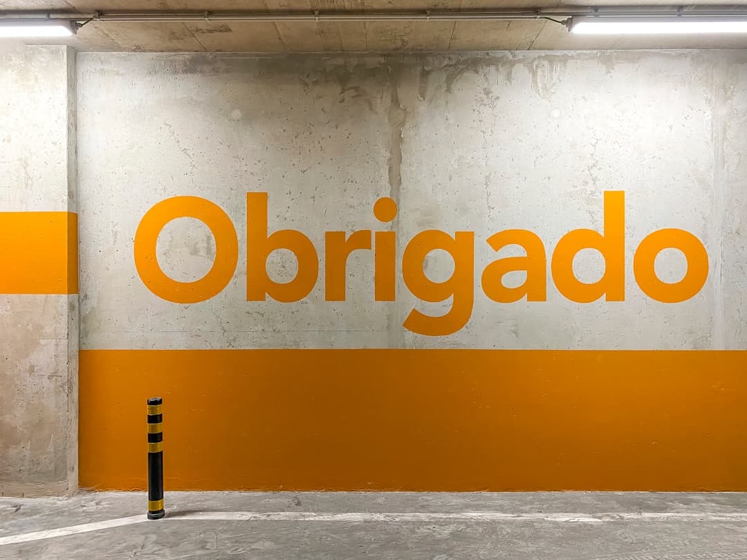 a yellow and white sign that reads obrigado — Photo by Etienne Girardet on Unsplash