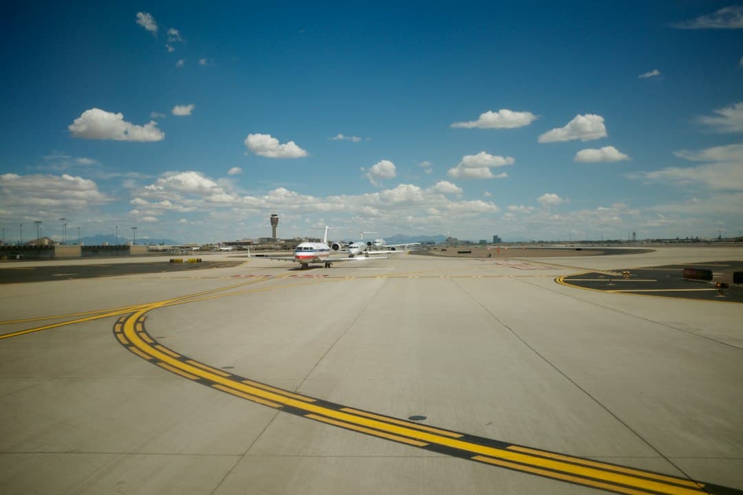 white and black plane on gray concrete road under blue sky during daytime — Photo by Joel Goodman on Unsplash