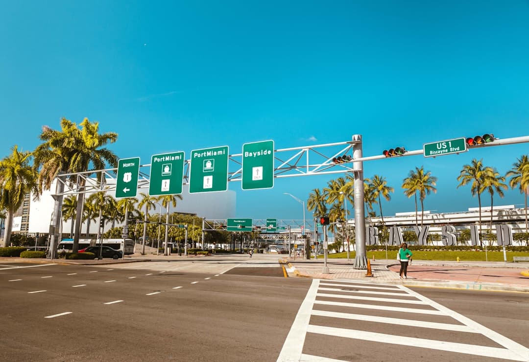 a street intersection with palm trees and street signs — Photo by Luis Santiago on Unsplash