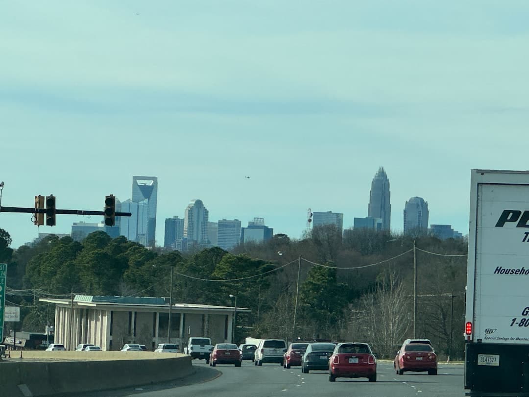 a truck is driving down the road in front of a city — Photo by KDavid Montero on Unsplash