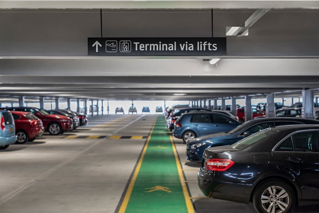 Cars parked in a multi-level parking garage with directional signage. — Photo by Holiday Extras on Unsplash