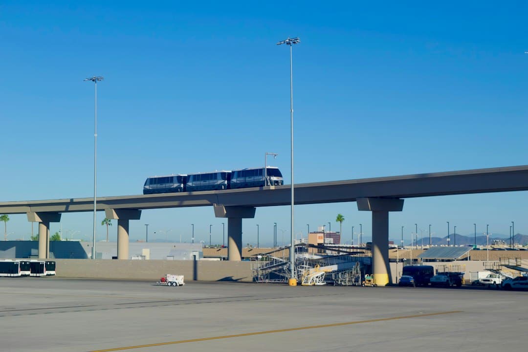 Monorail train travels on elevated track under blue sky — Photo by cool guy jon on Unsplash