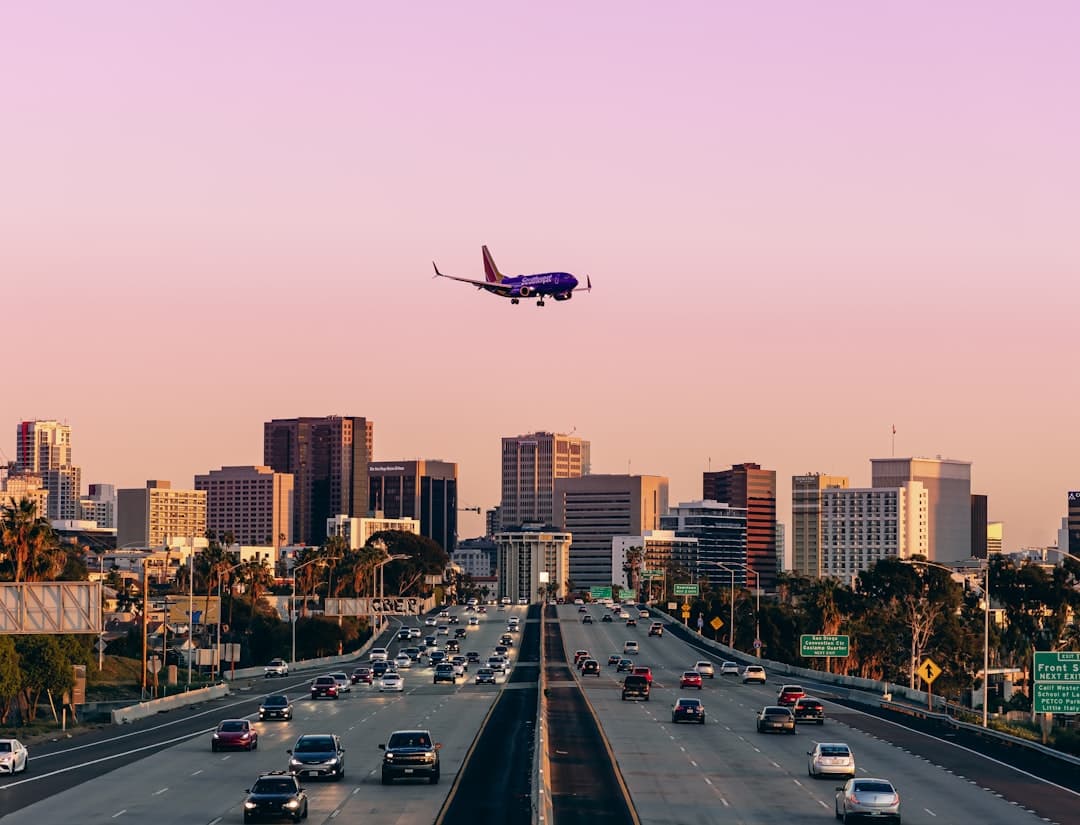 an airplane is flying over a busy highway — Photo by Reed Naliboff on Unsplash
