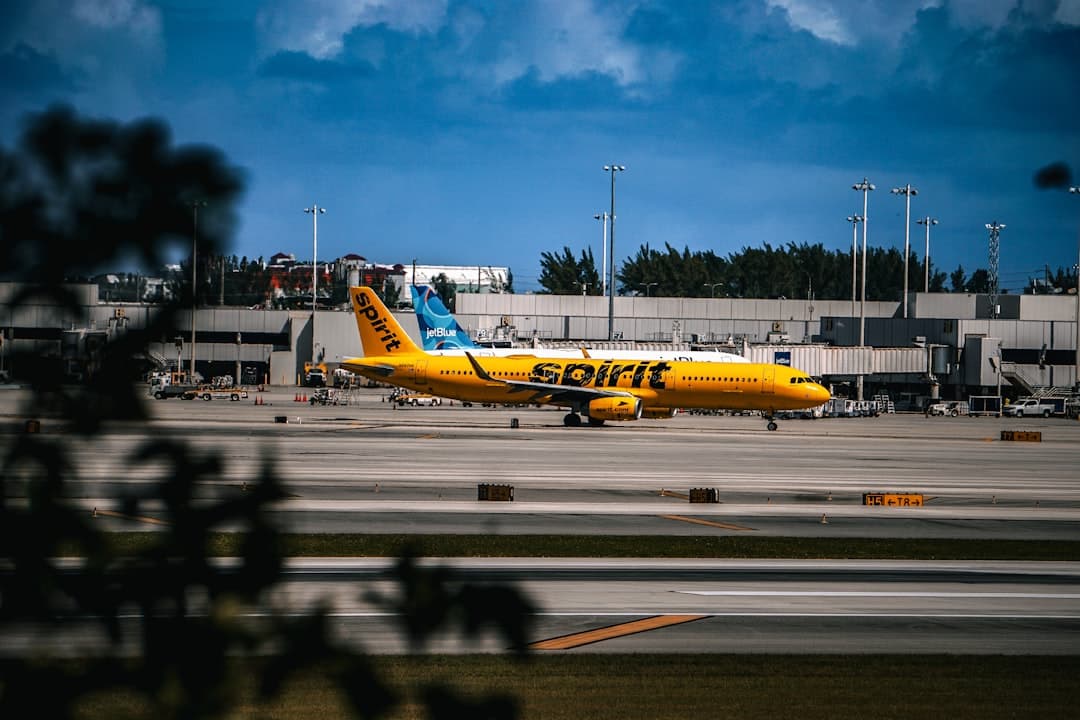 A yellow and blue plane is on the runway — Photo by Randolph Rojas on Unsplash