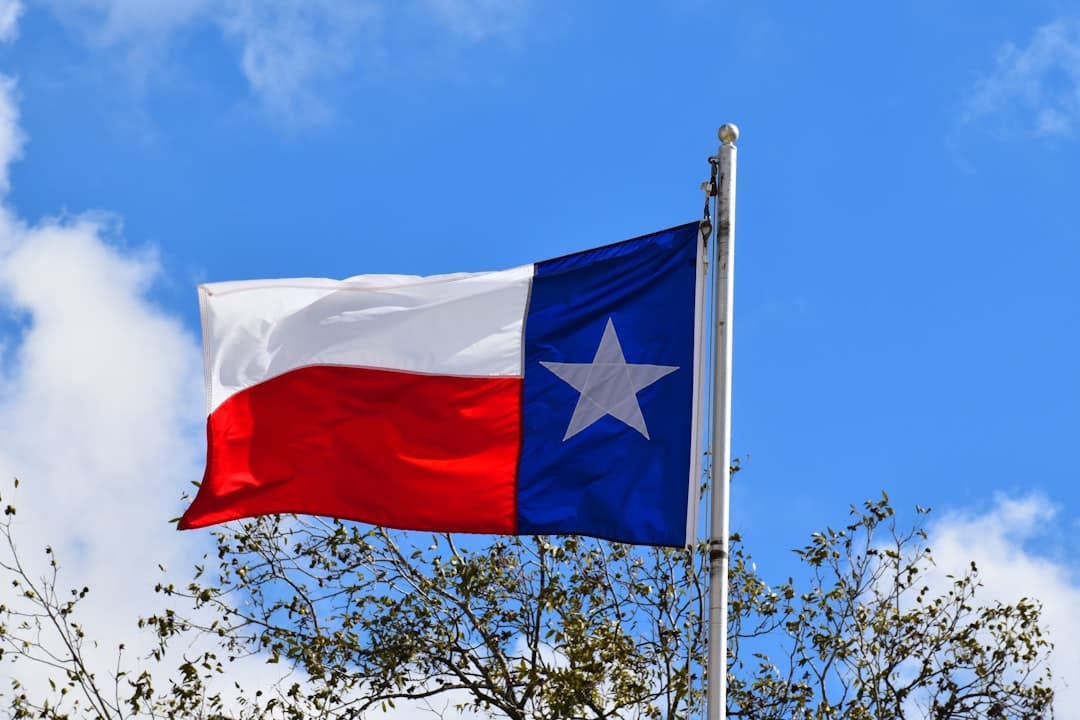 a texas state flag flying in the wind — Photo by Ray Shrewsberry on Unsplash