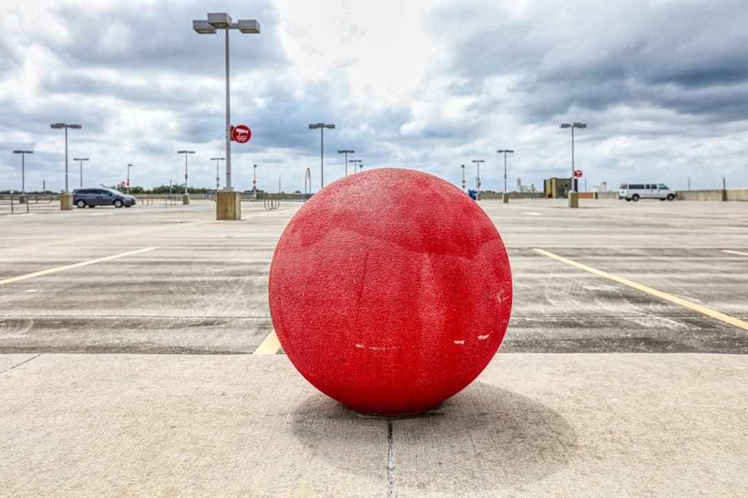 red round ball on gray concrete road during daytime — Photo by Mick Haupt on Unsplash