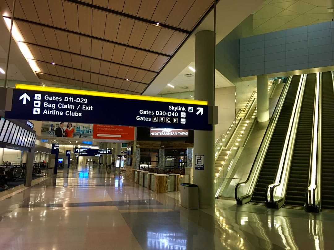 Airport terminal with escalators and signs — Photo by Jim Petkiewicz on Unsplash