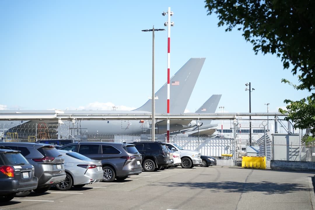 A parking lot full of parked cars next to an airplane — Photo by Brian Zhu on Unsplash