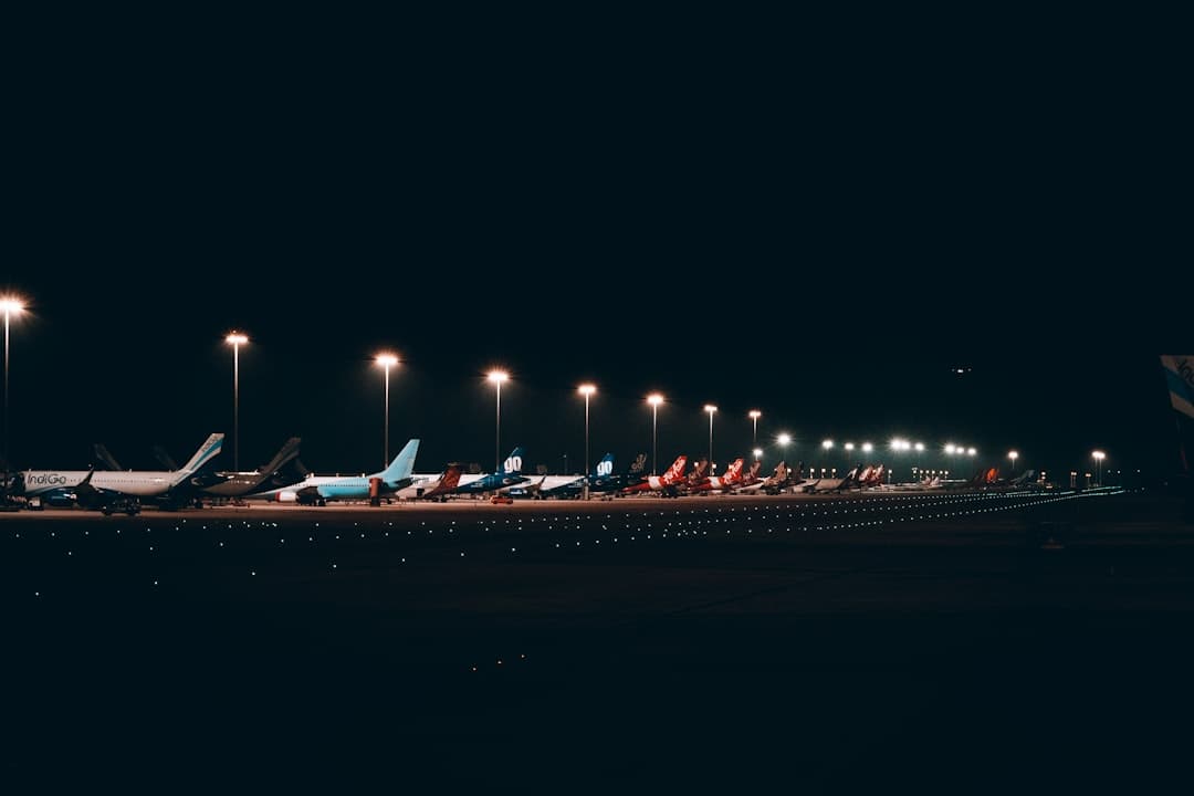 a row of airplanes sitting on top of an airport tarmac — Photo by Divyadarshi Acharya on Unsplash