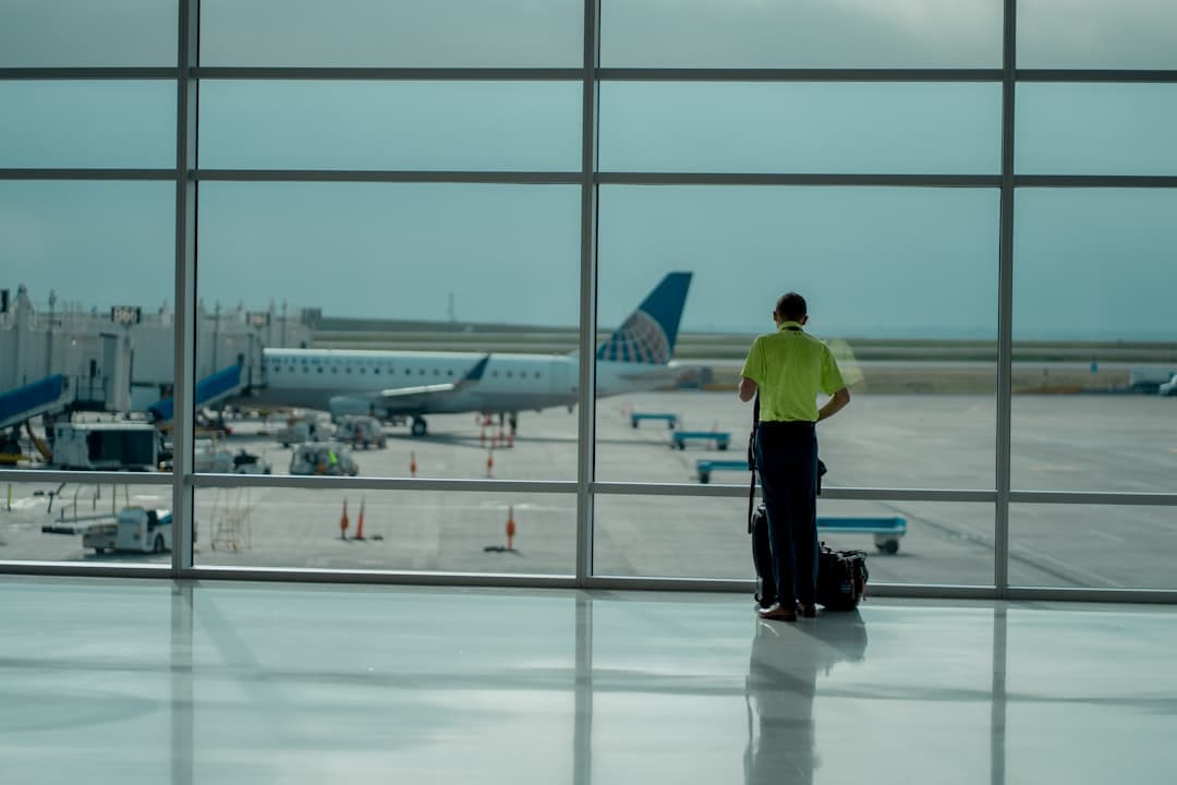 a man standing in front of an airport window — Photo by Cameron Cox on Unsplash