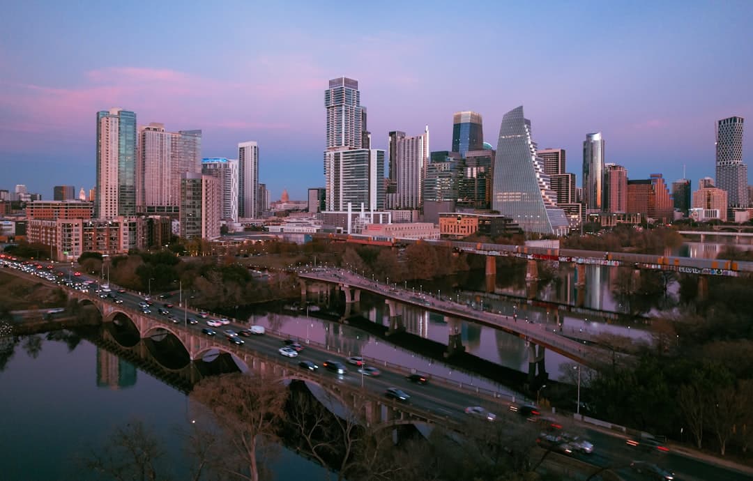 City skyline with bridges and river at dusk — Photo by Mark Cisneros on Unsplash