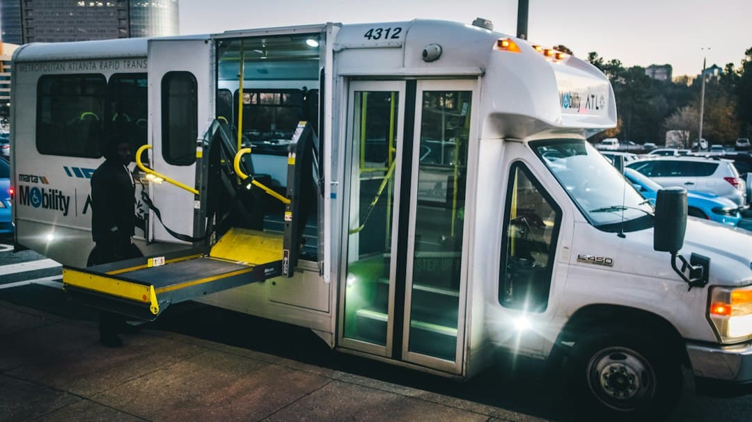 a city bus with its doors open and a ramp attached to it — Photo by Osarugue Igbinoba on Unsplash