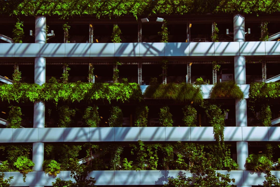 a building with a bunch of plants growing on the side of it — Photo by Jon Champaigne on Unsplash