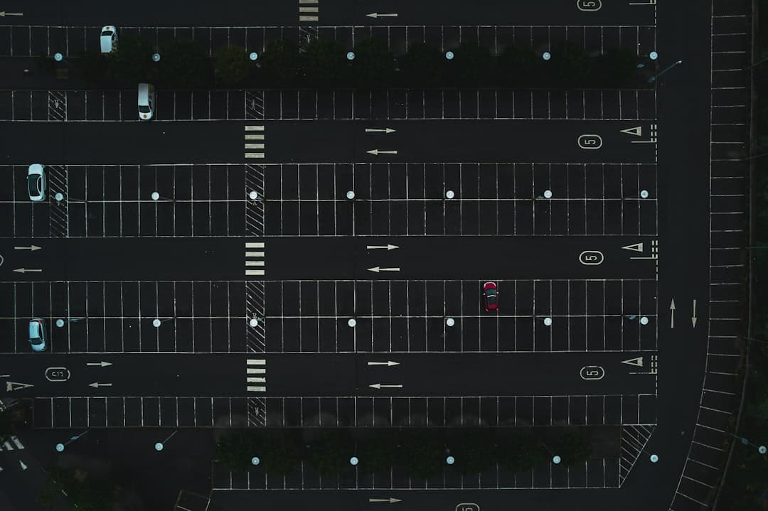 an overhead view of a parking lot at night — Photo by Jack B on Unsplash