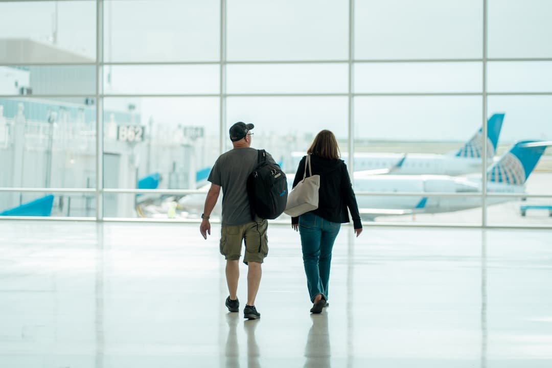 a man and a woman walking through an airport — Photo by Cameron Cox on Unsplash