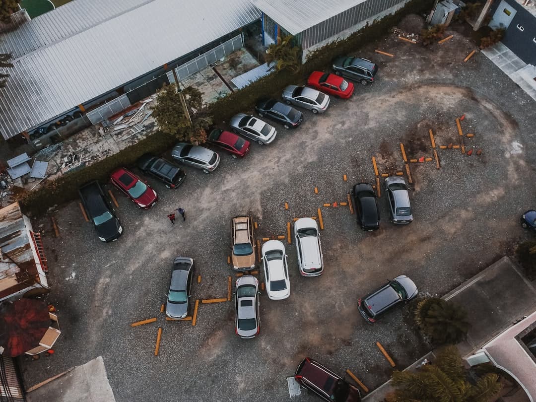aerial photography of assorted vehicles parked beside building at daytime — Photo by Angello Pro on Unsplash