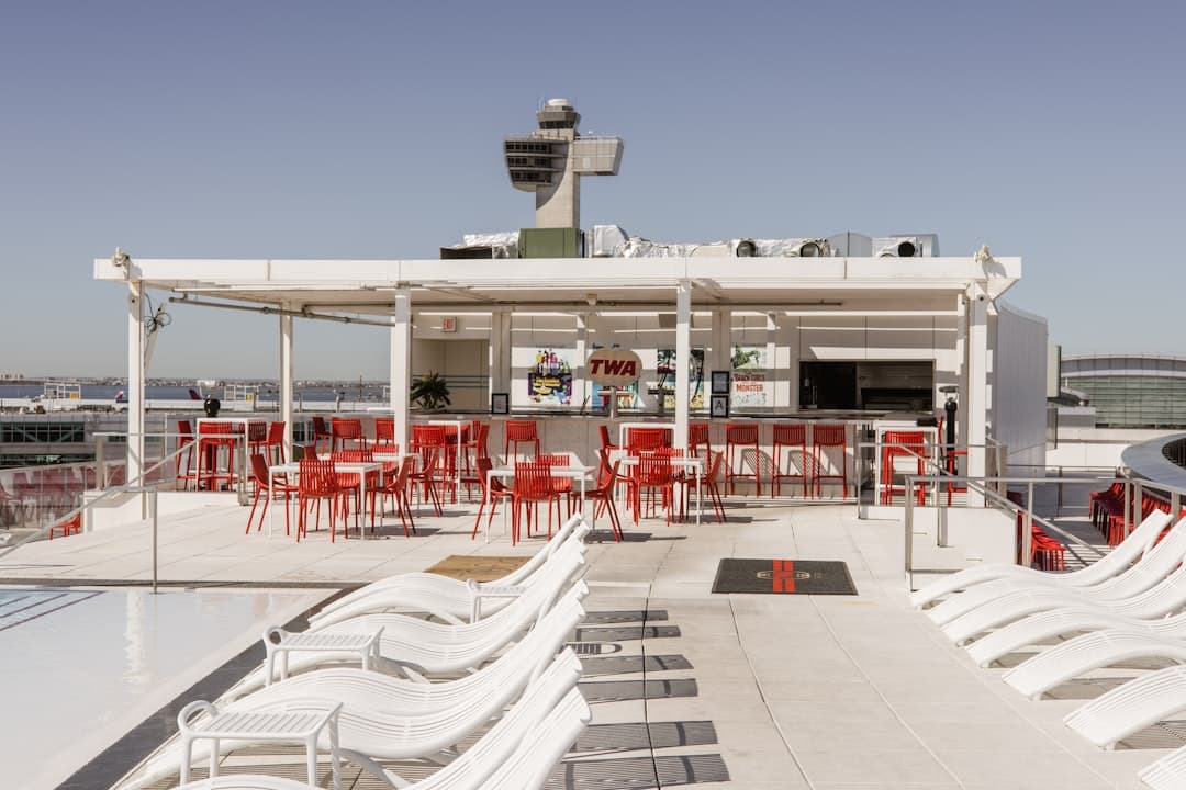 a group of red and white chairs sitting on top of a roof — Photo by Josh Withers on Unsplash