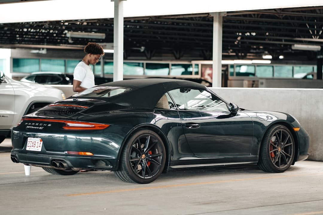 a person standing next to a black sports car — Photo by Ansspvt Titan on Unsplash