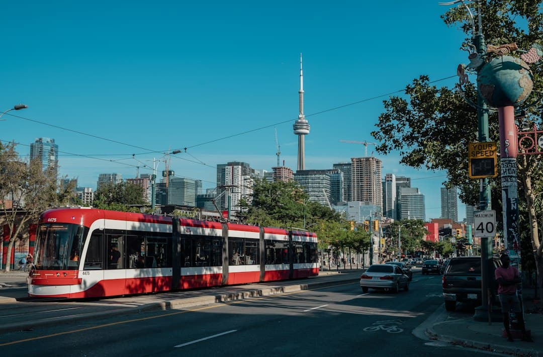 a red and white trolley on a street with cars and buildings in the background — Photo by Nick Smith on Unsplash