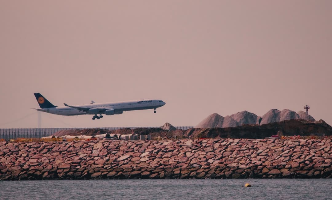 a large jetliner flying over a body of water — Photo by Sugarman Joe on Unsplash