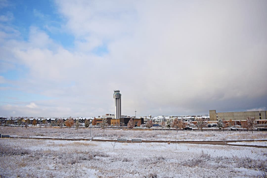 a snowy field with a clock tower in the background — Photo by Doni Rath on Unsplash
