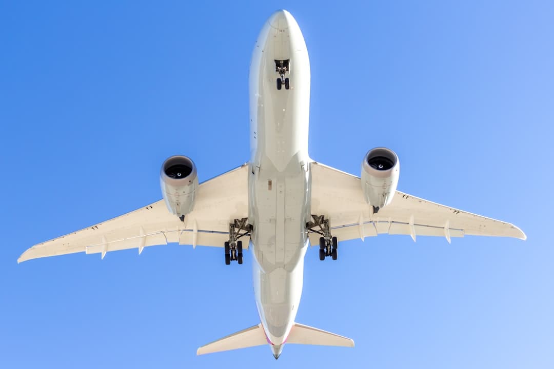 A large jetliner flying through a blue sky — Photo by Izyan Sultanali on Unsplash