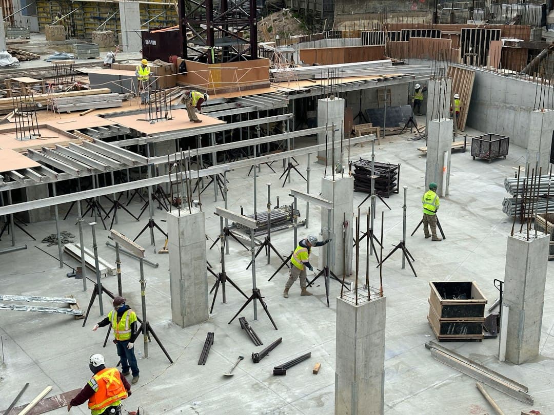 a group of men standing around a building under construction — Photo by Ray Donnelly on Unsplash