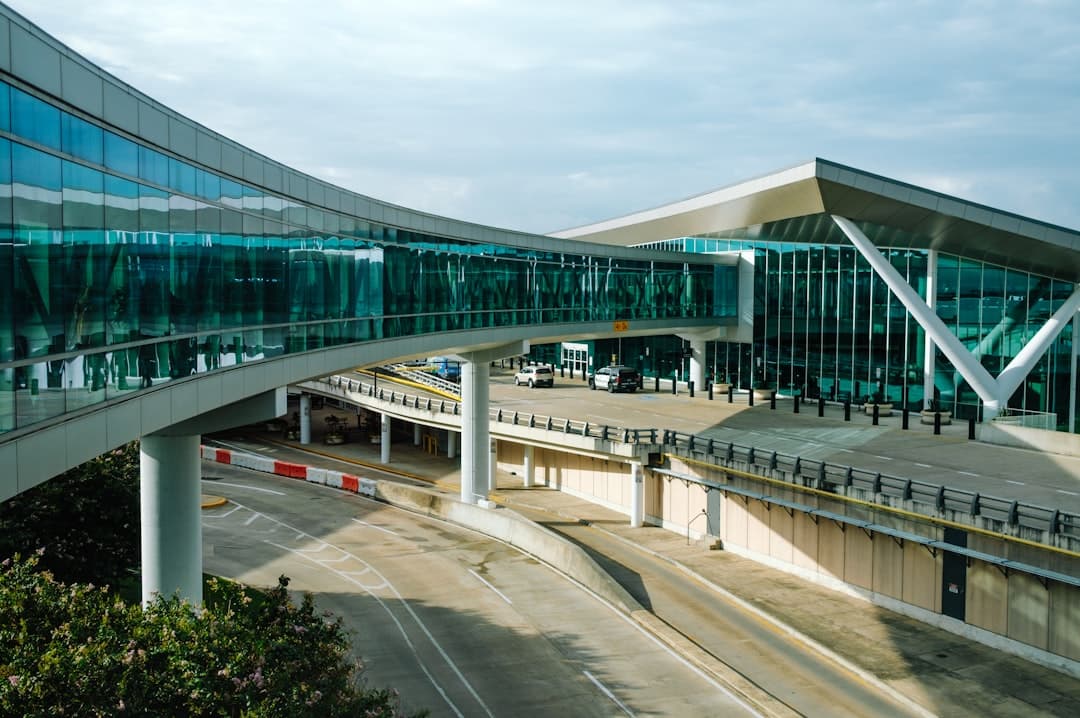 a curved walkway leads to an airport terminal — Photo by Jeswin Thomas on Unsplash