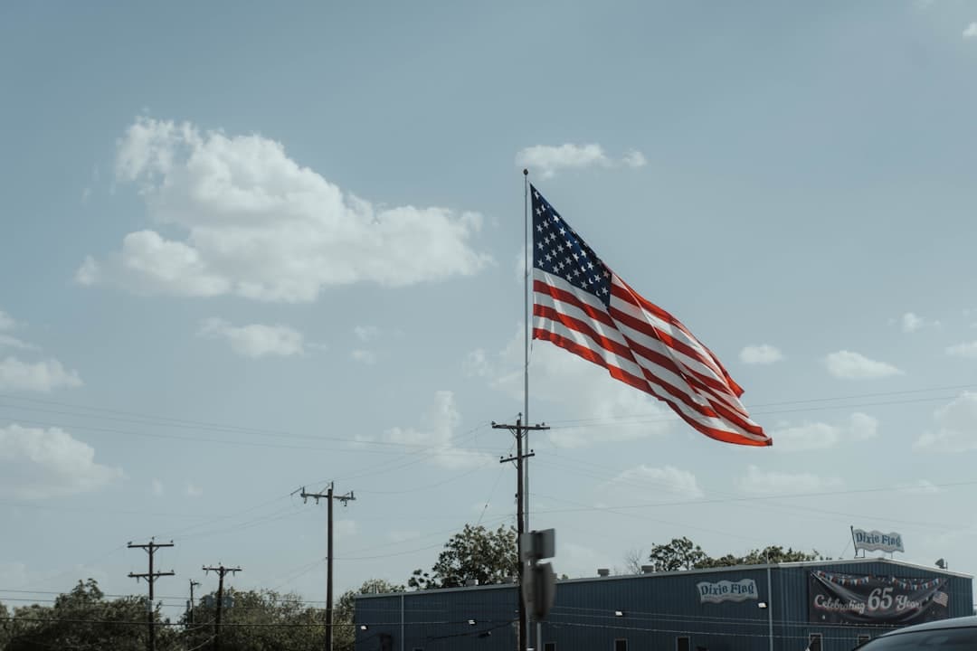 a large american flag flying in the air — Photo by Katt Galvan on Unsplash