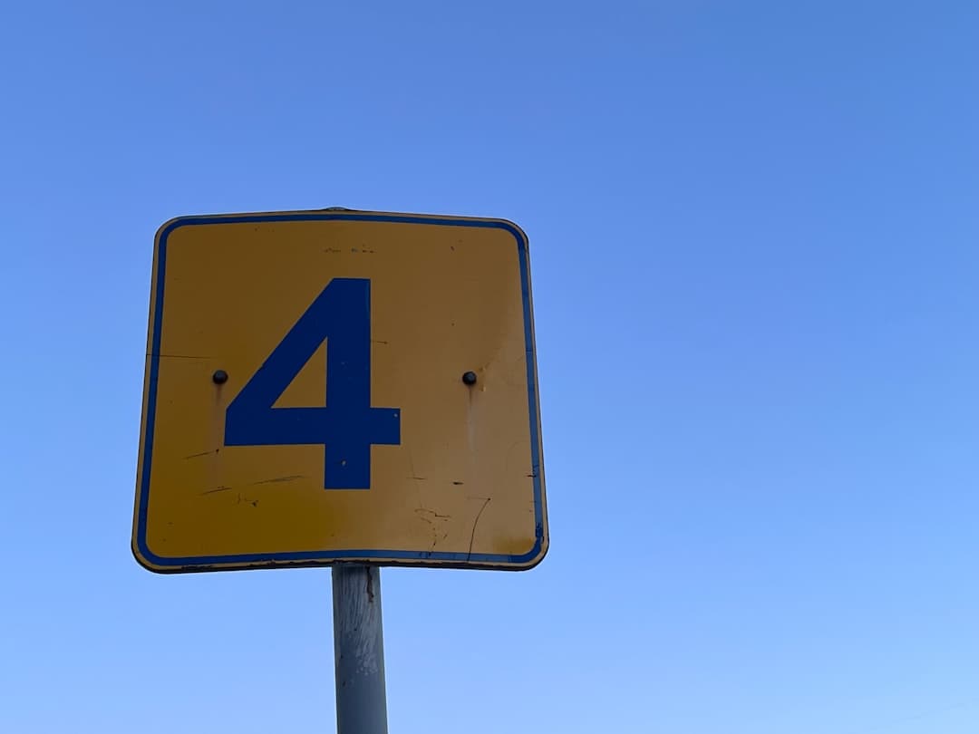 a street sign with the number four on it — Photo by Tasha Kostyuk on Unsplash