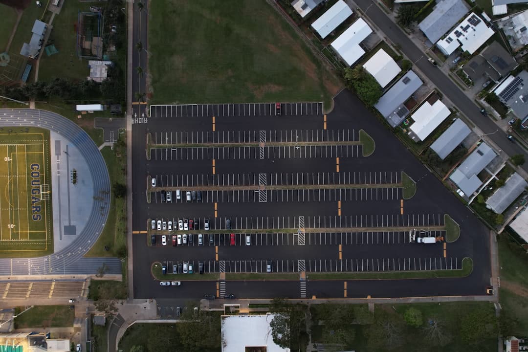an aerial view of an empty parking lot — Photo by Aidan Tottori on Unsplash