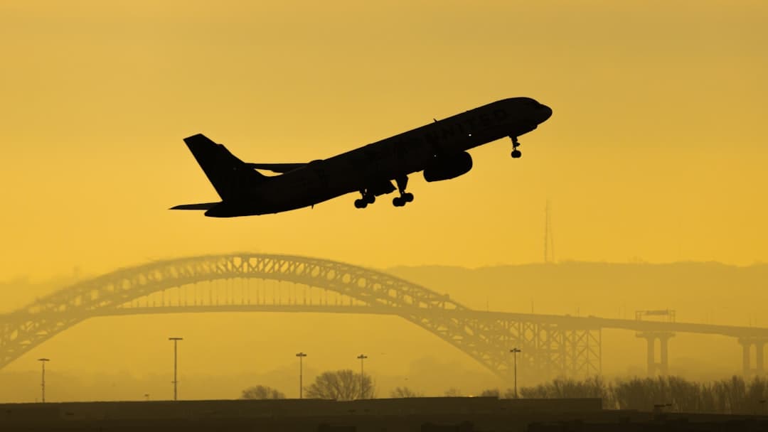 black airplane flying over the city during daytime — Photo by Bing Hui Yau on Unsplash